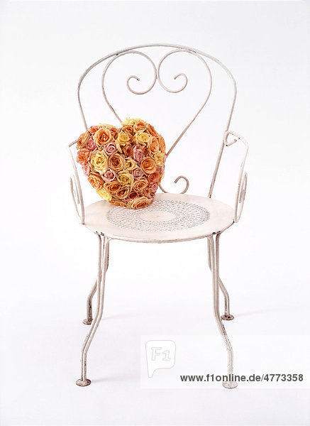 Heart of roses  pastel-coloured wedding bouquet  on a white metal chair