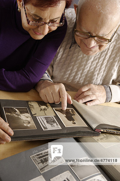 Old man  senior  92 years  and daughter  looking at a family album