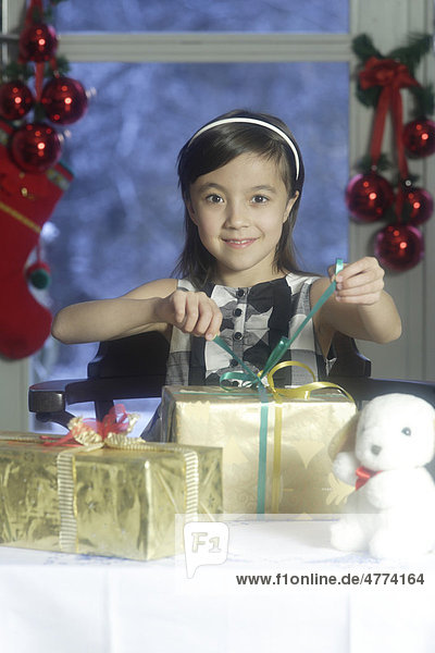 Mädchen  10 Jahre  beim Auspacken der Geschenke zu Weihnachten