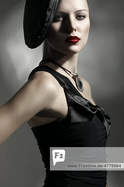 Junge Frau mit eleganter Mütze und schwarzem Kleid  Porträt