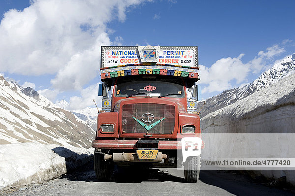 Passstraße Manali-Leh-Highway  alter roter Tata LKW auf Straße zwischen Schneewand  bei Keylong  Distrikt Lahaul und Spiti  Bundesstaat Himachal Pradesh  Indien  Südasien  Asien