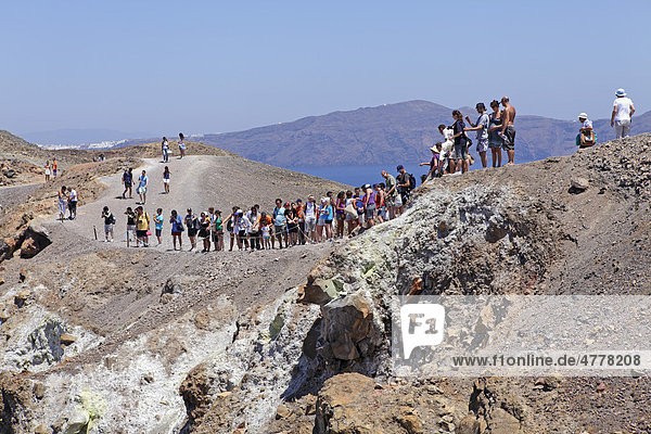 Climbing the volcano  volcanic island Nea Kameni  in the back Thira  Santorini  Cyclades  Aegean Sea  Greece  Europe