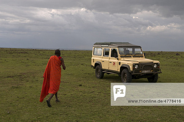 Mann der Volksgruppe der Massai oder Masai  mit Jeep  Masai Mara  Kenia  Afrika