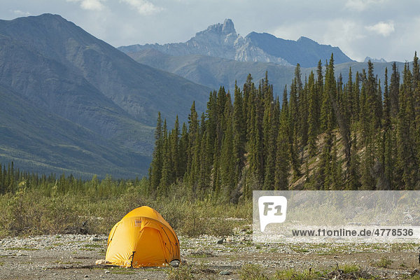 Expedition tent on a gravel bar  Northern Mackenzie Mountains behind  camping  Wind River  Yukon Territory  Canada