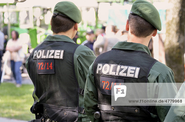 Two police officers watching a demonstration  back view  lettering Polizei or police  Munich  Bavaria  Germany  Europe