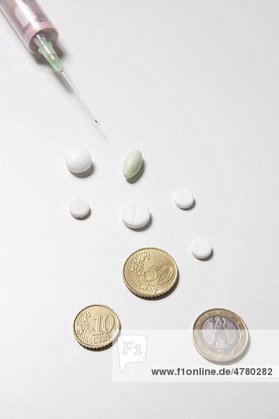 Syringe  tablets and coins  symbolic image for health costs