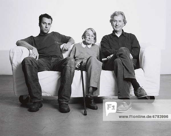 Three generations  a grandmother  her son and her grandson sitting on a sofa