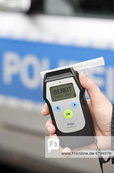 Police officer with breathalyser for checking the fitness to drive