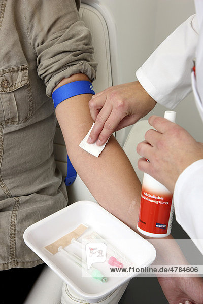 Arztpraxis  Blutabnahme zur Blutuntersuchung im Labor bei einer Patientin durch eine Praxishhilfe  medizinisch-technische Angestellte  Desinfektion