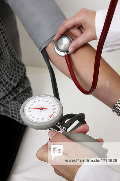 Arztpraxis  Sprechstundenhilfe  medizinisch-technische Angestellte  misst den Blutdruck einer Patientin