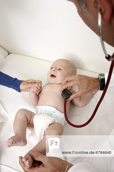 Arztpraxis  Kinderarzt bei der Untersuchung eines Säuglings  Vorsorgegrunduntersuchung  Abhorchen mit einem Stethoskop  U-Untersuchung