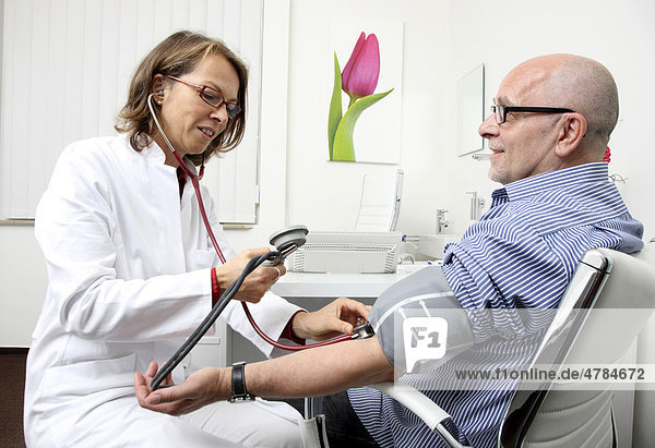 Arztpraxis  Ärztin mit Patient  Blutdruckmessung