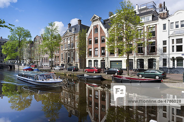 Tourist boat  old canal houses reflected in the water  Oudezijds Voorburgwal  Amsterdam  Holland  Netherlands  Europe