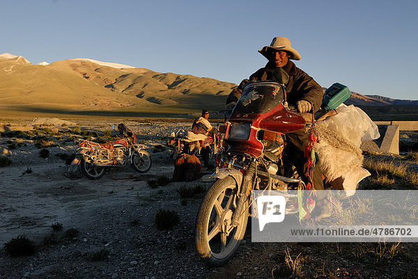 Tibetische Pilger mit geschmückten und bepackten Motorrädern auf dem Weg zum Berg Kailash  Hochebene Changtang bei den Lungkarbergen  Westtibet  Provinz Ngari  Tibet  China  Asien