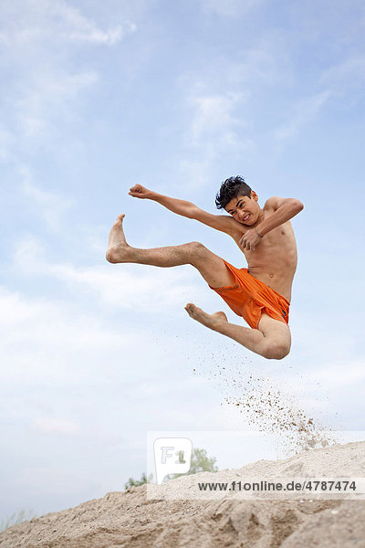 Ein Junge springt ausgelassen von einer Düne am Strand von Timmendorf auf der Insel Poel  Mecklenburg-Vorpommern  Norddeutschland  Deutschland  Europa