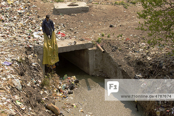 Mann entsorgt seinen Müll in Kanal  der in heiligen Fluss Bagmati mündet  Kathmandu  Nepal  Asien