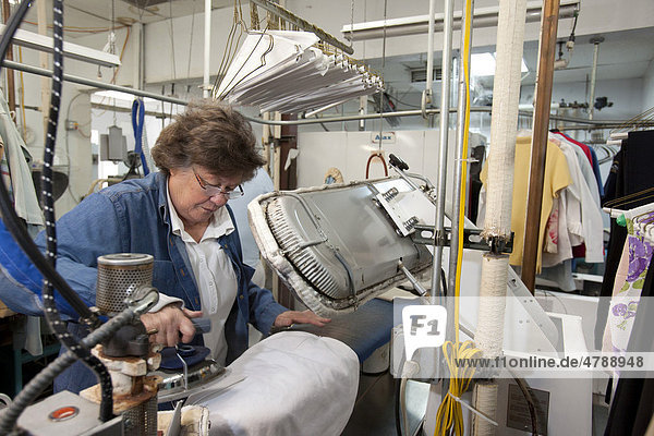 Mary Kay Valencia  Lionheart Cleaners  einer Wäscherei und Reinigung  bügelt ein Kleidungsstück  Broomfield  Colorado  USA  Amerika