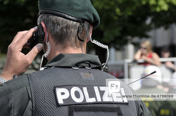 Policeman from the Evidence and Arrest Unit  BFE  using a mobile phone at a NPD rally in Ulm  Baden-Wuerttemberg  Germany  Europe