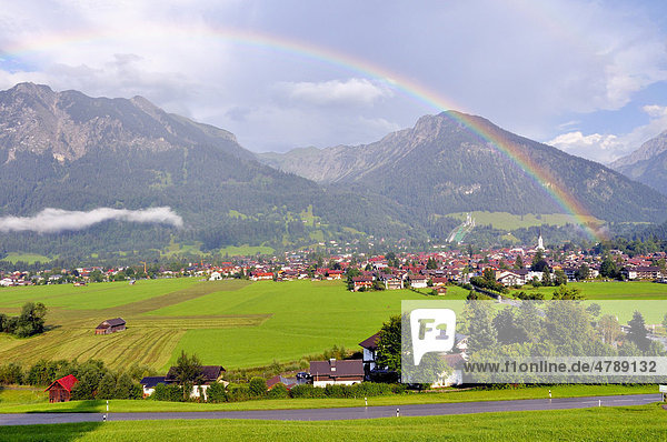 View across Oberstdorf with rainbow  Schattenberg mountain with Schattenberg ski jump at back  Oberallgaeu district  Bavaria  Germany  Europe