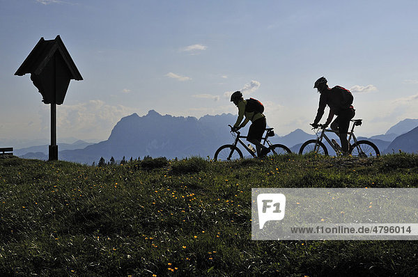 Mountain bikers on Eggenalm alpine pasture in front of Wilder Kaiser Mountains  Reit im Winkl  Bavaria  Germany  Europe  Tyrol  Austria  Europe