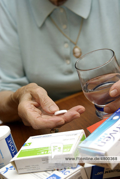 Ältere Frau nimmt Medikamente  Glas Wasser