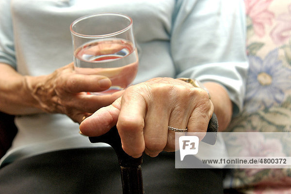 Ältere Frau trinkt ein Glas Wasser