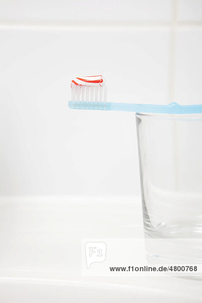 Zahnbürste mit Zahnpasta  Glas