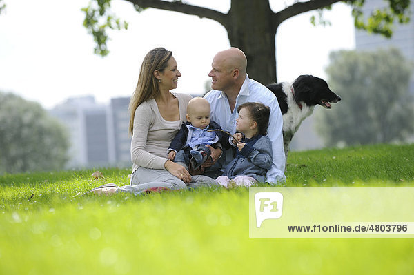 Glückliche Familie mit einem dreijährigen Mädchen  einem sechs Monate alten Jungen und einem Hund