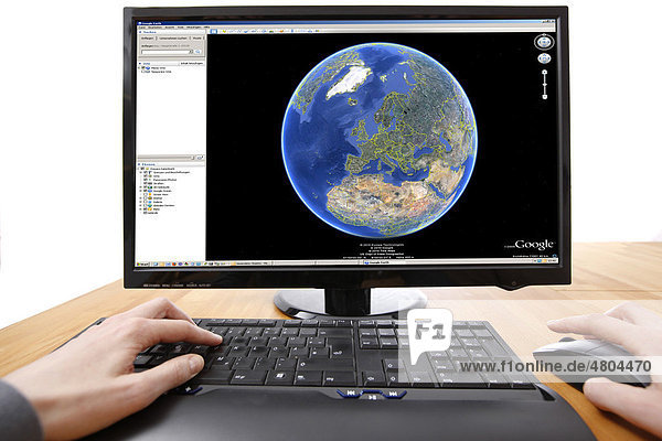 Person sitting at a computer working with Google Earth