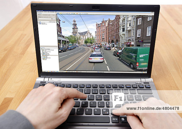 Person sitzt am Computer  arbeitet mit Google Street View  Detailbild von einem Teil der Innenstadt von Amsterdam  Personen und KFZ-Kennzeichen sind unkenntlich gemacht worden