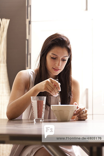 Young woman sitting comfortably at a dining table  having breakfast