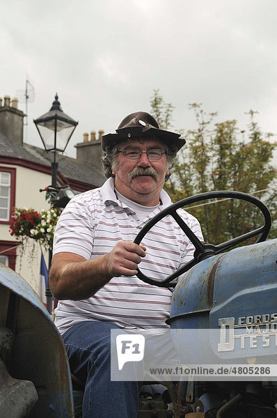 Irischer Farmer auf einem alten Schlepper bei einem Umzug auf dem Stadtfest von Birr  County Offaly  Midlands  Republik Irland  Europa