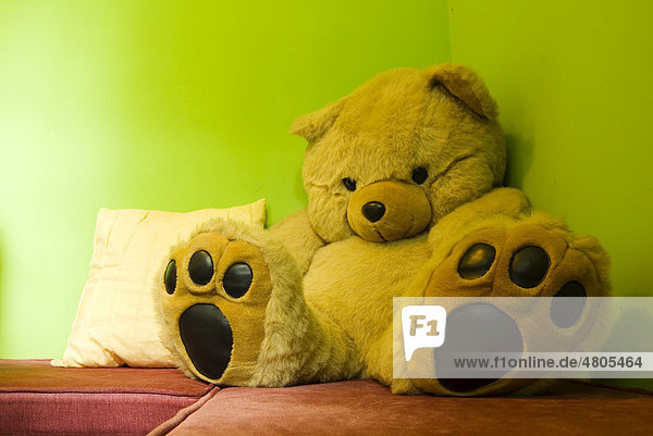 Teddybär sitzt einsam in einer Ecke