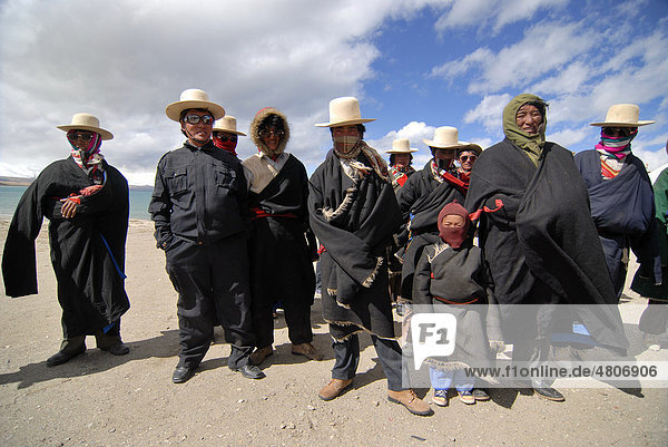 Tibetische Männer und Kinder einer Pilgergruppe bei einer Pilgerfahrt am See Manasarovar in der näheren Umgebung des heiligen Berges Mount Kailash  oder tibetisch Kang Rinpoche  Provinz Ngari  Westtibet  Himalaya  Tibet  China  Asien