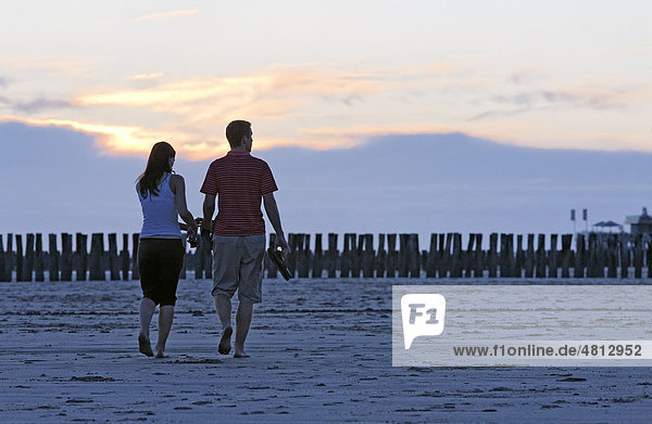 Young couple taking a walk on the beach at sunset  Zoutelande  Walcheren peninsula  Zeeland province  Netherlands  Benelux  Europe