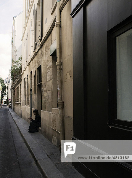Frau am Straßenrand sitzend  Paris  Frankreich  Europa