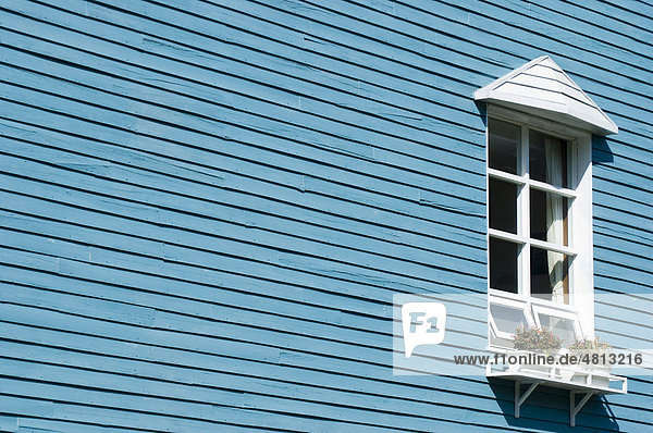 Weißes Fenster an blauer hölzerner Hauswand