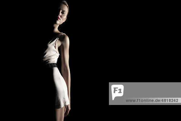 Junge Frau in weißem Kleid umrahmt von Licht und Schatten  Fashion