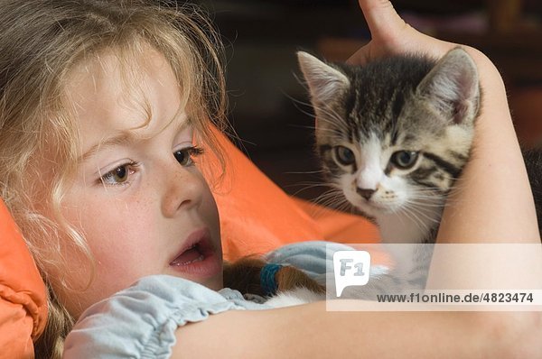 Mädchen schaut auf ihr Haustier Katze
