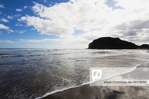 New Zealand  North Island  Surfers in tasman sea at bethells beach