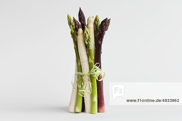 Bundle of various asparagus on white background