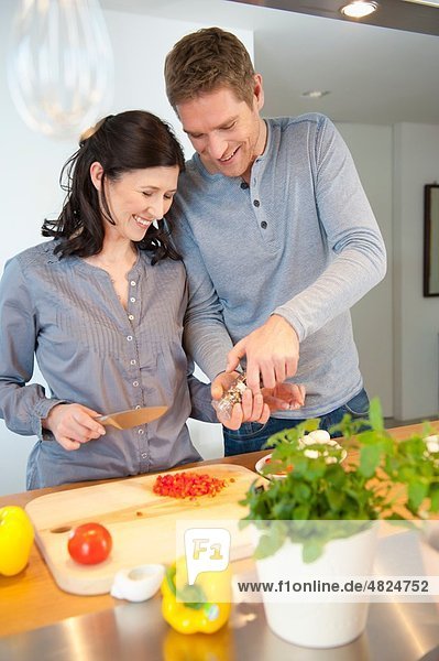 Mann und Frau kochen in der Küche  lächelnd
