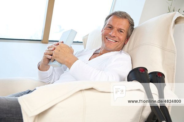 Erwachsener Mann auf Stuhl sitzend  lächelnd  Portrait