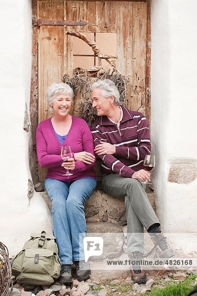 Italy  South Tyrol  Mature couple with wine glass at mountain hut