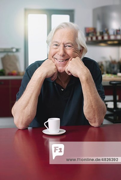 Senior man with coffee cup  smiling  portrait