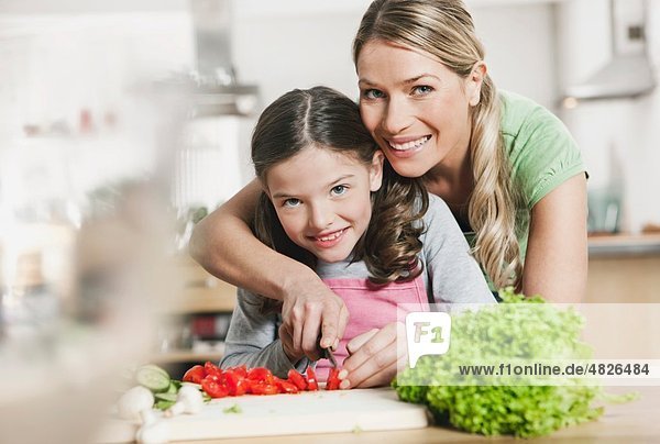 Deutschland  Mutter und Tochter bei der Zubereitung von Salat