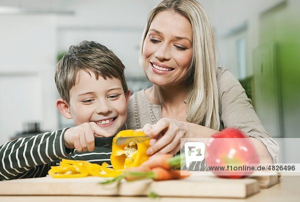 Deutschland    Mutter und Sohn schneiden Gemüse in der Küche
