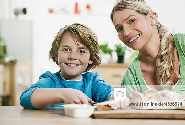 Deutschland    Mutter und Sohn beim Brotschneiden in der Küche
