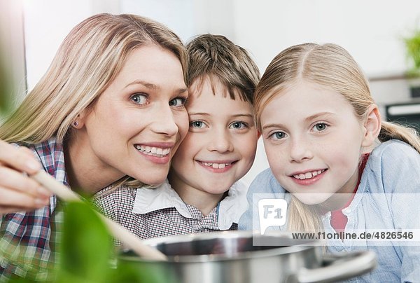 Deutschland    Mutter und Kinder in der Küche  lächelnd  Portrait