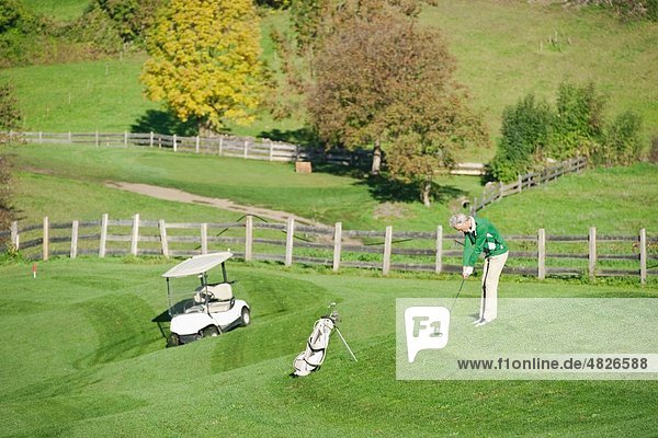 Italien  Kastelruth  Reifer Mann beim Golfspielen auf dem Golfplatz